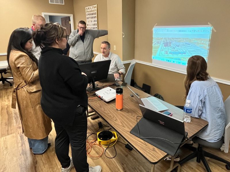 Residents gathered around a table and projector screen, viewing Olde Town design concepts