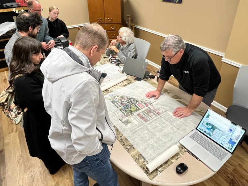 Residents gathered around a table, reviewing Olde Town design concepts on a paper map
